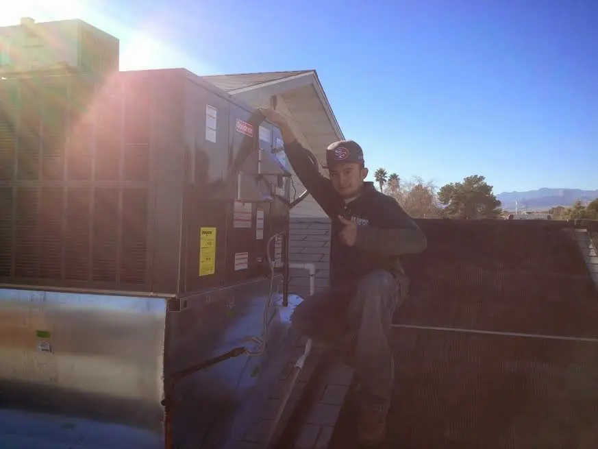 HVAC technician performing AC Tune-Up on a rooftop unit in Holdenville